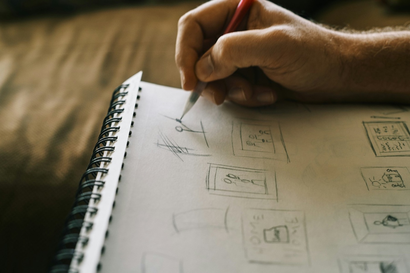 Hand skizziert mit Bleistift die Struktur einer neuen Website als einfache Layout-Rahmen in ein Notizbuch