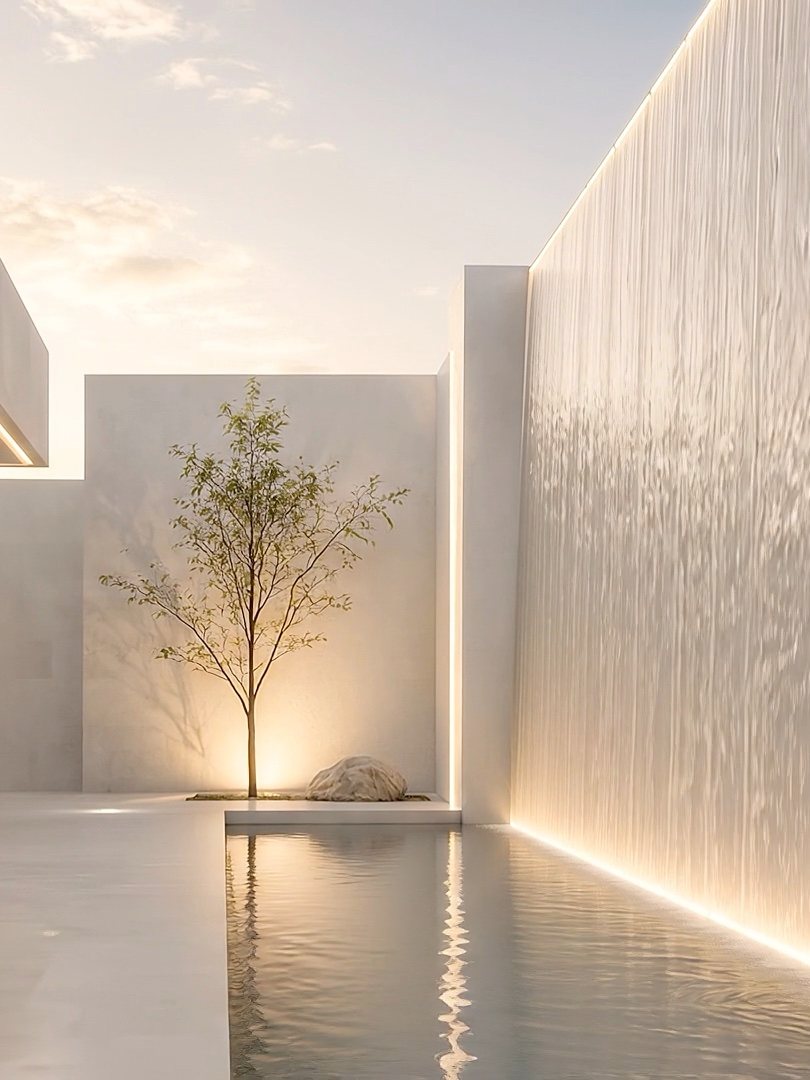 Heller moderner Innenhof mit beleuchteter Wasserwand und einzelnem Baum